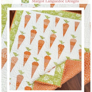 May include: A handmade quilt featuring a repeating pattern of orange carrots with green tops on a white background. The quilt has a floral patterned border and is labeled "Carrot Patch" with the website address.
