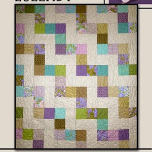 May include: A quilt with a patchwork design featuring squares in shades of purple, green, teal, and gold, set against a cream background. The word "LULLABY" is at the top, and "Villa Rosa Designs" is at the bottom.