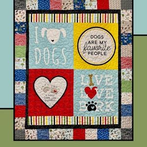 May include: A colorful quilt with the words "Puppy Love" at the top. The quilt features dog-themed designs, including hearts, paw prints, and the phrase "Dogs are my favorite people." The quilt is designed by Tamara Cook for Villa Rosa Designs.