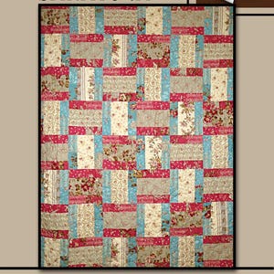 May include: A patchwork quilt with the word "SARATOGA" at the top. The quilt features a pattern of rectangular blocks in shades of red, blue, beige, and floral prints. A white rose is in the upper right corner. The text "Villa Rosa Designs" is at the bottom.