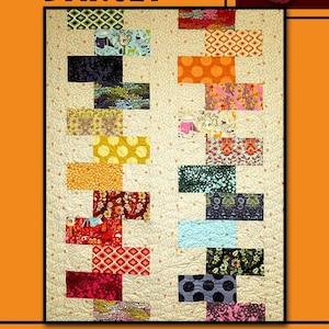 May include: Darcey quilt pattern with a cream background and colorful rectangular fabric blocks. The blocks feature various patterns and colors, including floral, geometric, and abstract designs. The text "Darcey" and "Villa Rosa Designs" are also visible.