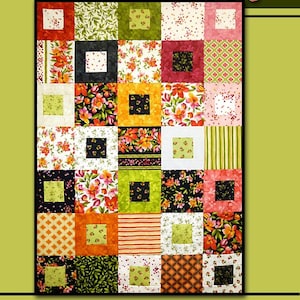 May include: A quilt pattern called "Pandemonium" by Villa Rosa Designs. The quilt is made up of a grid of colorful squares with different floral and geometric patterns. The quilt is surrounded by a border of green leaves and pink flowers.