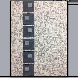 Könnte beinhalten: Ein gestepptes Textil mit dem Wort "MOONDANCE" oben. Die Steppdecke zeigt ein Muster aus grauen Formen auf hellem Hintergrund, mit einer vertikalen Spalte aus dunkelgrauen Quadraten. Eine weiße Rose befindet sich in der oberen rechten Ecke.