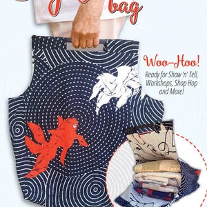 May include: A blue and white fabric tote bag with a red and white fish design. The bag is open to show the interior, which is lined with a beige fabric. The bag is labeled "The Big Mouth Bag" and "Woo-Hoo! Ready for Show 'n' Tell, Workshops, Shop Hop and More!" The bag is also labeled "Black Cat Creations" and "Designed by Amy Cotham".