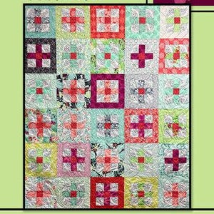May include: A quilt pattern called "Electron" by Villa Rosa Designs. The quilt is made up of a grid of colorful squares with a variety of patterns. The quilt is surrounded by a border of green and red leaves.
