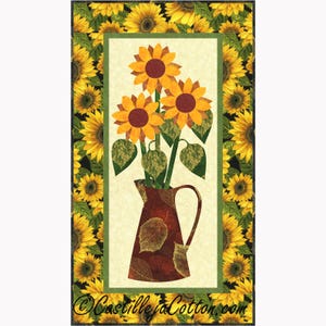 May include: A fabric panel featuring a vase of sunflowers. The sunflowers are yellow and orange with brown centers, set against a cream background. The vase is brown with leaf patterns. The panel is framed with a border of sunflowers.