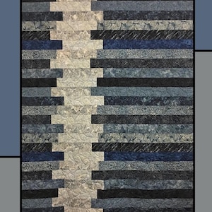 Puede incluir: Un edredón con un diseño geométrico, con rayas horizontales en tonos de azul, gris y negro, con un camino vertical central de color beige claro. El edredón se titula "Midnight Pathway" y está diseñado por Molly Cook para Villa Rosa Designs.