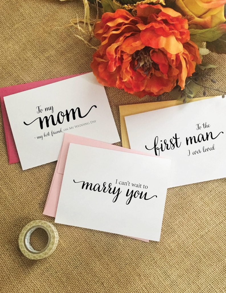 Puede incluir: Tres tarjetas de boda con caligraf&iacute;a manuscrita. La primera tarjeta es rosa y dice "To my mom - my best friend, on my wedding day". La segunda tarjeta es blanca y dice "I can't wait to marry you". La tercera tarjeta es amarilla y dice "To the first man I ever loved".