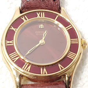 Vintage Seiko Gold Tone Women&#39;s Ruby Red Bezel Dial Watch Roman Numerals Leather
