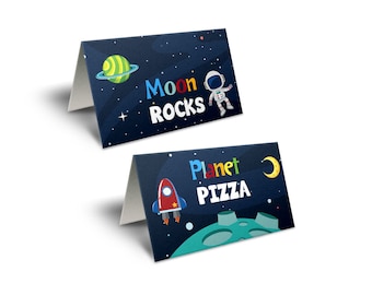 May include: Two space-themed food labels with a dark blue background and colorful text. The first label says "Moon Rocks" and features an astronaut and a planet. The second label says "Planet Pizza" and features a rocket and a crescent moon.