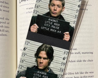 May include: A bookmark featuring two images of men holding signs that read "LITTLE ROCK CITY POLICE" and "LITTLE ROCK A.R.". The bookmark is rectangular and has a clear plastic overlay.