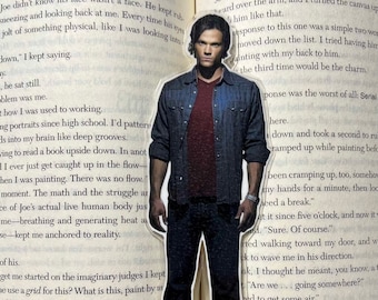 May include: A close-up of a book with a bookmark featuring a man in a blue shirt and jeans. The book is open to a page with the text "Hello Stranger" and "Katherine Center".