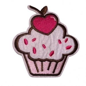 May include: A white cupcake with pink icing and sprinkles, topped with a pink heart-shaped cherry. The cupcake is outlined in brown.
