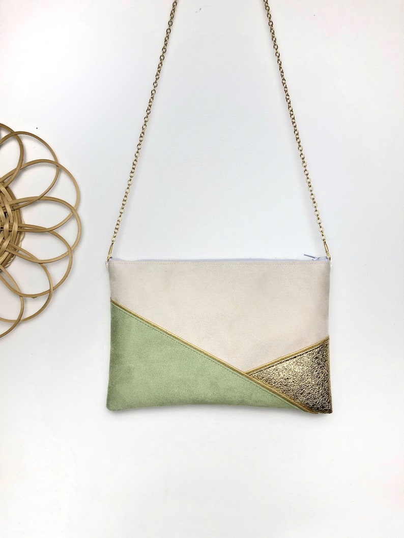 K&ouml;nnte beinhalten: Eine beige, gr&uuml;ne und goldene Clutch mit einer goldenen Kettenkette.