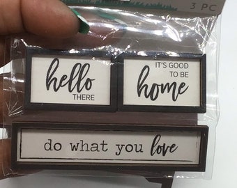 Puede incluir: Tres letreros de madera con marcos negros y fondos blancos. Los letreros tienen el siguiente texto: "hello there", "it's good to be home" y "do what you love".