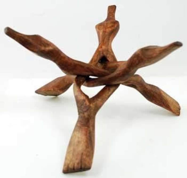 Op de afbeelding: Houten standaard voor het tentoonstellen van kristallen of andere kleine objecten. De standaard heeft een driehoekige basis en drie gebogen armen die bovenaan samenkomen tot een punt.