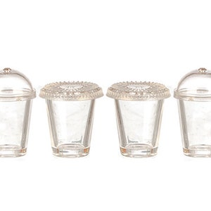 May include: Set of four clear plastic cups with lids. The cups are designed to look like disposable cups with lids, but are smaller in size. They are perfect for dollhouses or miniature play sets.
