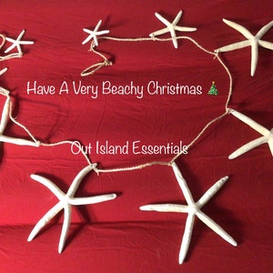 May include: A white starfish garland with the text "Have A Very Beachy Christmas" and "Out Island Essentials".