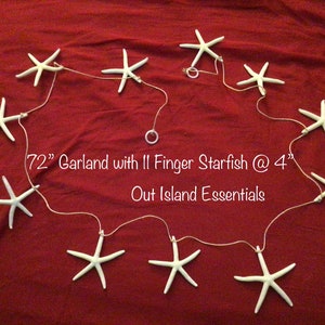 May include: A 72-inch garland with 11 white finger starfish, each measuring 4 inches in diameter, strung on a white cord. The garland is displayed on a red fabric background. The text "72" Garland with 11 Finger Starfish @ 4" Out Island Essentials" is printed below the garland.