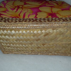 Puede incluir: Una cesta tejida con un patr&oacute;n floral en la parte superior y un fondo tejido. La cesta est&aacute; hecha de materiales naturales y tiene un borde marr&oacute;n.
