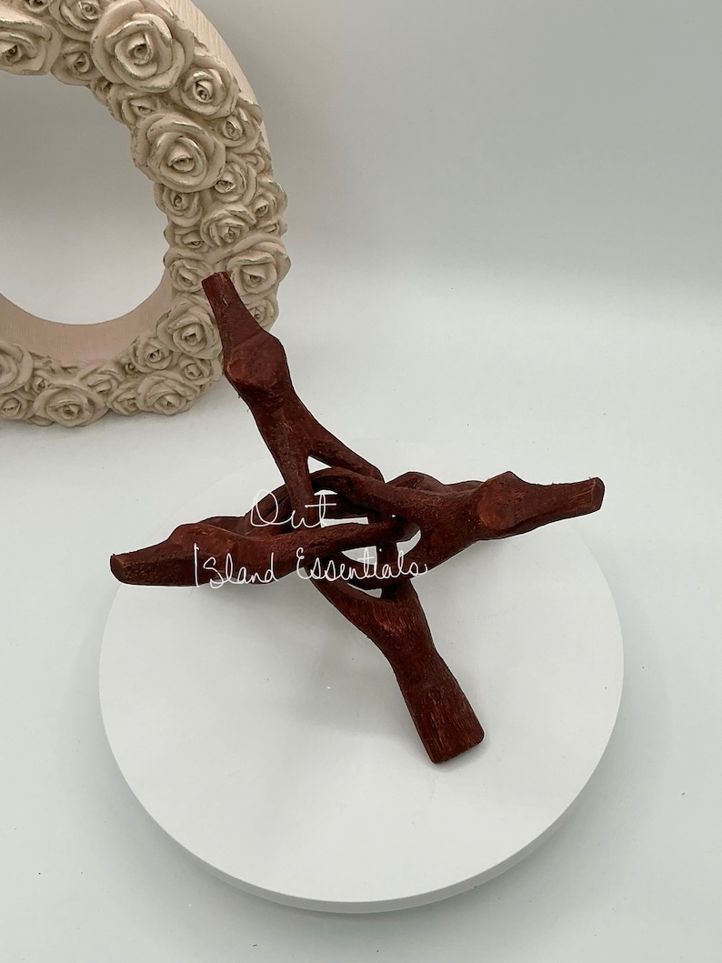 Op de afbeelding: Een handvormige houten standaard met een donkerbruine afwerking. De standaard is gemaakt van natuurlijk hout en heeft een unieke, rustieke uitstraling. De standaard is perfect om kleine items te presenteren, zoals sieraden, kaarsen of andere decoratieve objecten.
