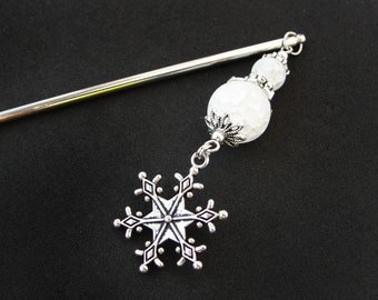 Könnte beinhalten: Silberner Haarstick mit einer weißen Perle und einem Schneeflocken-Anhänger. Die Perle ist texturiert und hat ein silbernes Filigranmuster.