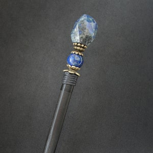 May include: A black wooden hair stick with a blue lapis lazuli gemstone and gold accents.