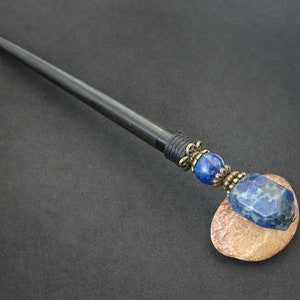 May include: Black wooden hair stick with a lapis lazuli gemstone and brass accents.