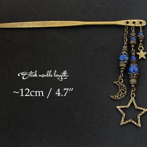 Puede incluir: Una varita para el pelo dorada con una cuenta de lapisl&aacute;zuli azul y un dije de estrella que cuelga. La varita mide aproximadamente 12 cm de largo. "Stick usable length: ~12cm / 4.7" est&aacute; escrito en la imagen.