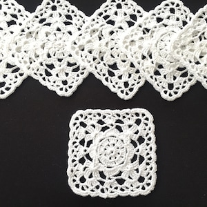 Puede incluir: Un conjunto de siete manteles individuales de ganchillo blanco con un delicado patrón floral. Los manteles individuales están dispuestos en una fila, con un mantel individual en el centro debajo de la fila.