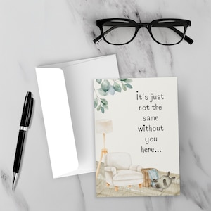 Könnte beinhalten: Grußkarte mit dem Text "It's just not the same without you here..." mit einer Aquarellillustration einer Wohnzimmerszene mit einem weißen Sessel, einer Lampe und einem Hund. Enthält einen weißen Umschlag, einen schwarzen Stift und eine schwarze Brille.