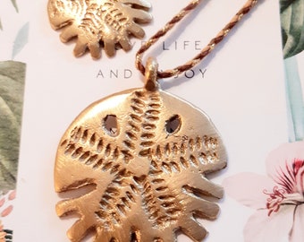 Pendentif talisman..porte-bonheur..grigri..dollar des sables..symbole d' Afrique et Caraïbes..en provenance de Côte d'Ivoire..bronze..rare.