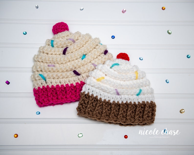 Peut inclure: Deux bonnets en crochet en forme de cupcake, l'un avec un gla&ccedil;age rose et l'autre avec un gla&ccedil;age brun. Les deux bonnets ont un gla&ccedil;age blanc et des p&eacute;pites color&eacute;es.