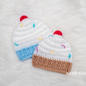 Peut inclure: Deux bonnets en crochet en forme de cupcake, l'un avec du gla&ccedil;age bleu et l'autre avec du gla&ccedil;age brun. Les deux bonnets ont du gla&ccedil;age blanc et des p&eacute;pites color&eacute;es.