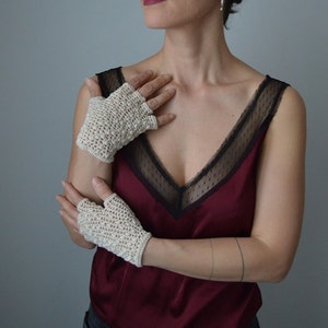 Peut inclure: Une paire de mitaines en crochet de couleur blanc cass&eacute;. Les mitaines sont r&eacute;alis&eacute;es avec un point d&eacute;licat et ont une surface l&eacute;g&egrave;rement textur&eacute;e.