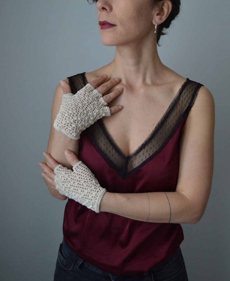 Peut inclure: Une paire de mitaines en crochet de couleur blanc cass&eacute;. Les mitaines sont r&eacute;alis&eacute;es avec un point d&eacute;licat et ont une surface l&eacute;g&egrave;rement textur&eacute;e.