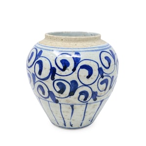 May include: A ceramic jar with a rounded body and a wide mouth, featuring a speckled off-white base color. The exterior is decorated with hand-painted cobalt blue swirling patterns around the upper section and vertical lines near the base.