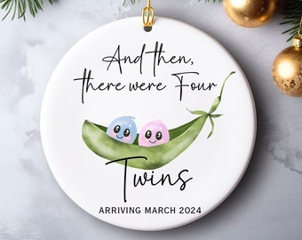 May include: White ceramic Christmas ornament with a green pea pod and two peas inside. The peas are blue and pink and have smiling faces. The text on the ornament reads "And then, there were four twins arriving March 2024".
