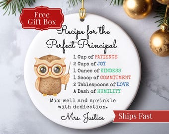 May include: White ceramic ornament with a gold hanging loop. The ornament features an owl illustration and text that reads "Recipe for the Perfect Principal." Includes the text "Free Gift Box."