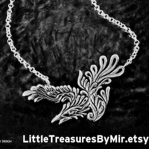 May include: A silver necklace featuring a detailed, stylised bird pendant. The bird is facing right and has a long, pointed beak. The necklace is displayed on a black velvet background. The text "LittleTreasuresByMir.etsy.com" is visible at the bottom of the image.