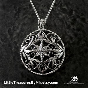 May include: A silver pendant necklace with a floral design. The circular pendant features intricate leaf and vine patterns within a beaded border. The necklace has a delicate chain and is displayed against a dark background. The text "LittleTreasuresByMir.etsy.com" is visible.
