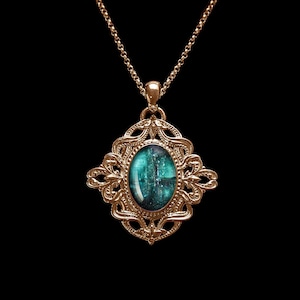 Puede incluir: Un collar de cadena de oro con un colgante que presenta una piedra ovalada azul turquesa engastada en un marco de oro adornado.