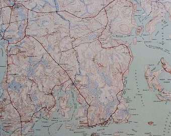 May include: A vintage topographic map with contour lines, roads, and bodies of water. The map features shades of brown, blue, and white, depicting a coastal region with bays, islands, and towns. The map is detailed and appears to be from the mid-20th century.
