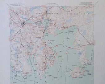 May include: A vintage topographic map of the Maine coastline, featuring the Machias Bay area. The map displays land elevation with contour lines, water bodies in blue, and place names. The map includes the Atlantic Ocean and is printed on aged paper.
