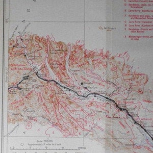 May include: A vintage geologic and topographic map of the Northern Pacific Route from St. Paul, Minnesota, to Seattle, Washington. The map, from 1915, features detailed geographical information with red and black lines and text.