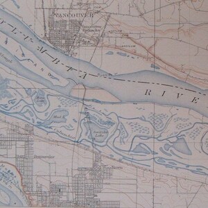 May include: A vintage map of the Columbia River, showing the river's course through the city of Vancouver, Washington. The map includes the names of various landmarks, including Swan Island, Hayden Island, and the Columbia River.