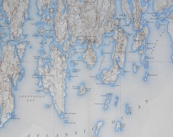 May include: A detailed black and white map of a coastal area with a blue overlay showing the water. The map includes the names of various islands, bays, and other geographical features. The map is titled "SHEEPSCOT BAY".