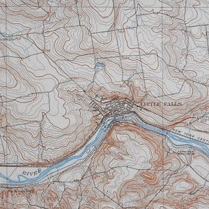 May include: A vintage topographic map of Little Falls, New York, showing the Mohawk River, the New York Central and Hudson River Railroad, and surrounding terrain with elevation contour lines.