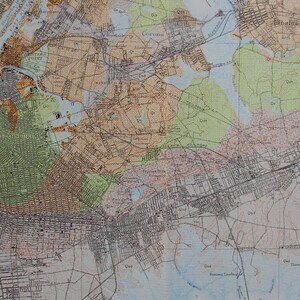 Puede incluir: Un mapa vintage de la ciudad de Nueva York, que muestra los distritos de Manhattan, Brooklyn, Queens y el Bronx. El mapa está impreso en blanco y negro con acentos marrones y verdes. El mapa muestra las calles, los parques y las masas de agua de la ciudad.