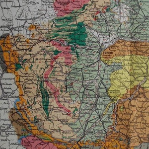 May include: An antique map of a region, featuring a detailed network of roads and geographical features. The map uses a variety of colors, including pink, green, yellow, and brown, to differentiate areas. Text labels identify cities and landmarks.